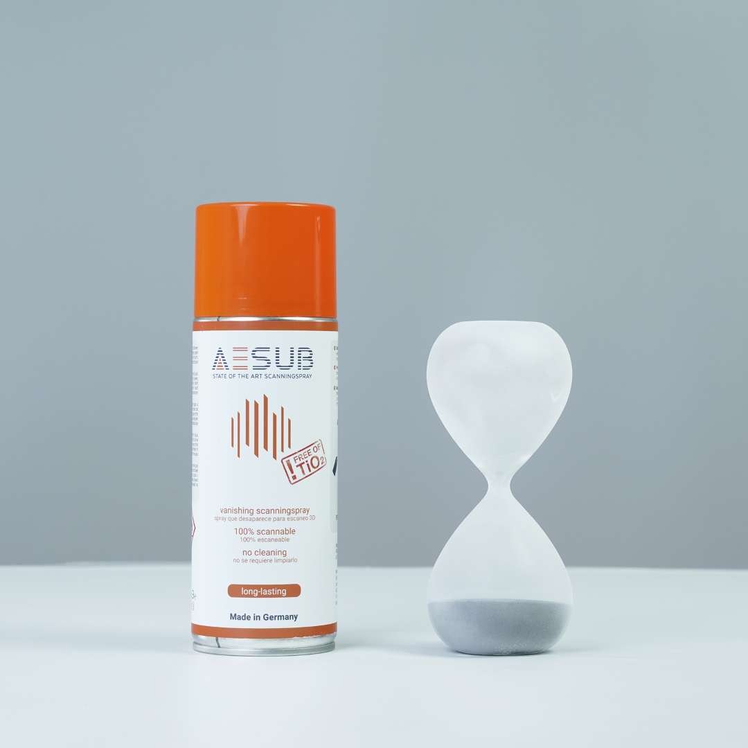 Bote de spray AESUB Orange junto a un reloj de arena de vidrio transparente con la arena en la parte inferior, que demuestra la sublimación completa tras la sesión de escaneo sin residuos visibles