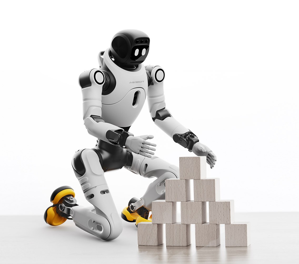 El robot humanoide blanco y negro AgiBot X2 está de rodillas frente a una pirámide de bloques de madera sobre un fondo claro.