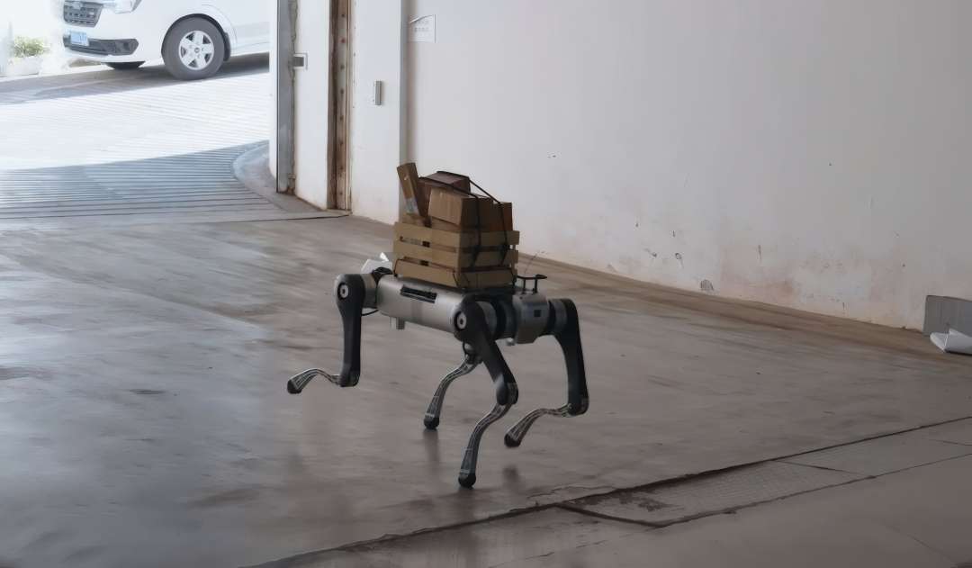 Robot cuadrúpedo caminando por el suelo de hormigón de un almacén con paquetes de cartón sujetos con correas sobre el lomo