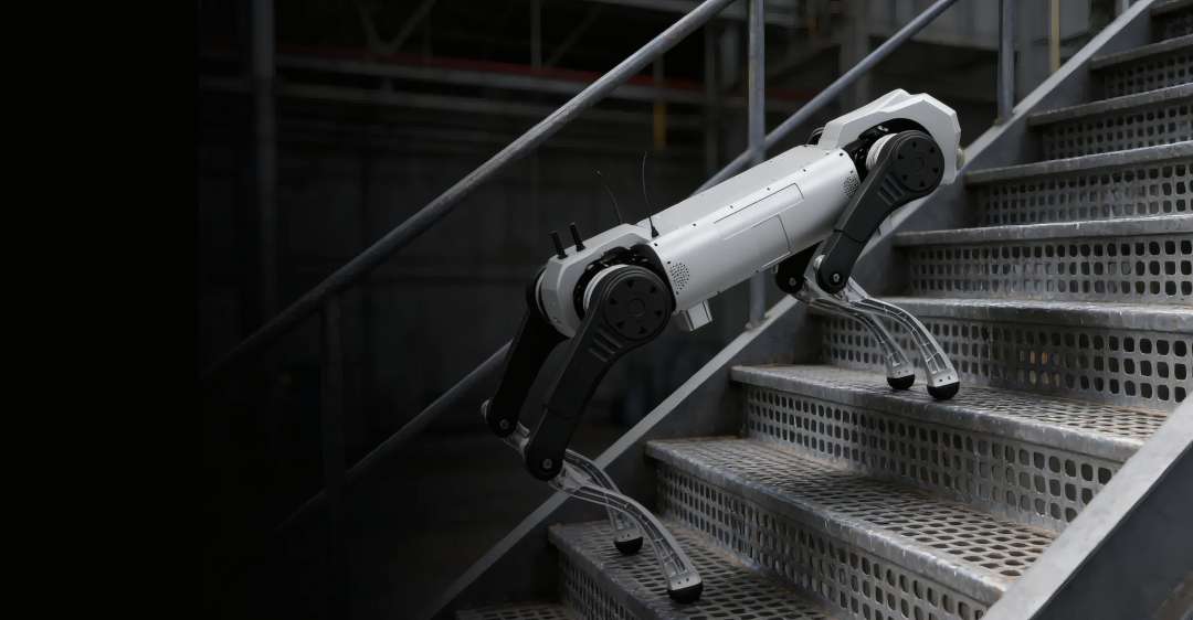 Robot cuadrúpedo blanco recorriendo unas escaleras industriales metálicas perforadas sobre cuatro patas articuladas