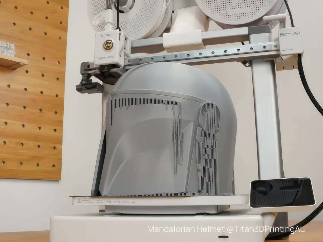 Impresora 3D fabricando un gran casco gris en una plataforma de 256×256×256 mm