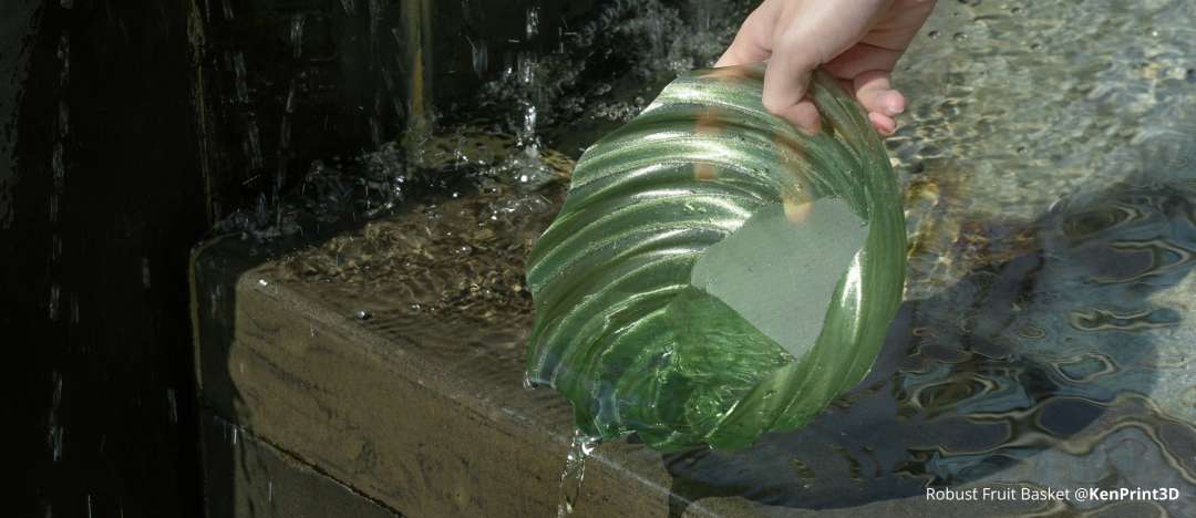 Cuenco impreso en 3D con PETG verde translúcido sostenido sobre agua, demostrando la claridad visual, la adhesión en superficie mojada y la integridad estructural de las paredes impresas