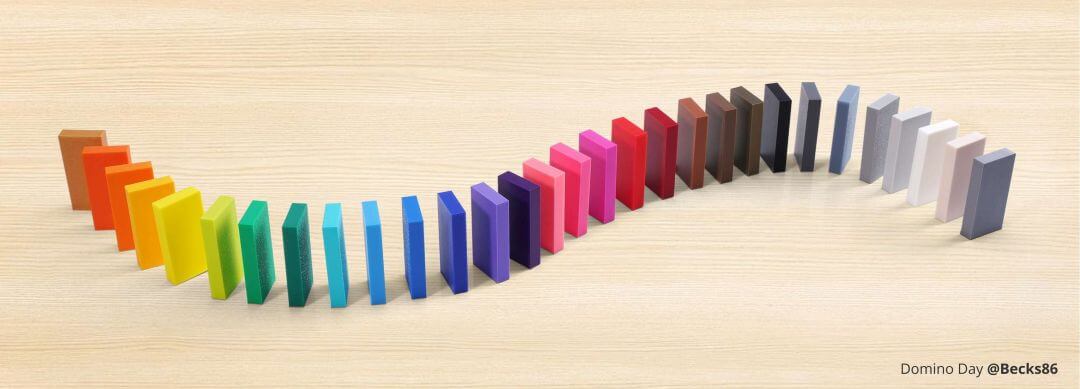 Variedad de colores de filamento Bambu PLA Basic - una línea de fichas de dominó de colores dispuestas en forma de S sobre una superficie de madera clara.