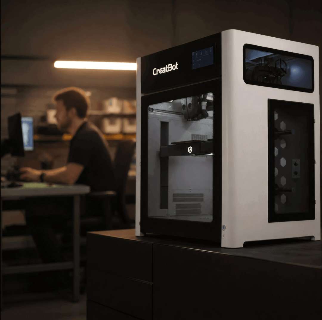 Impresora 3D cerrada CreatBot sobre un escritorio con un espacio de trabajo de oficina de fondo
