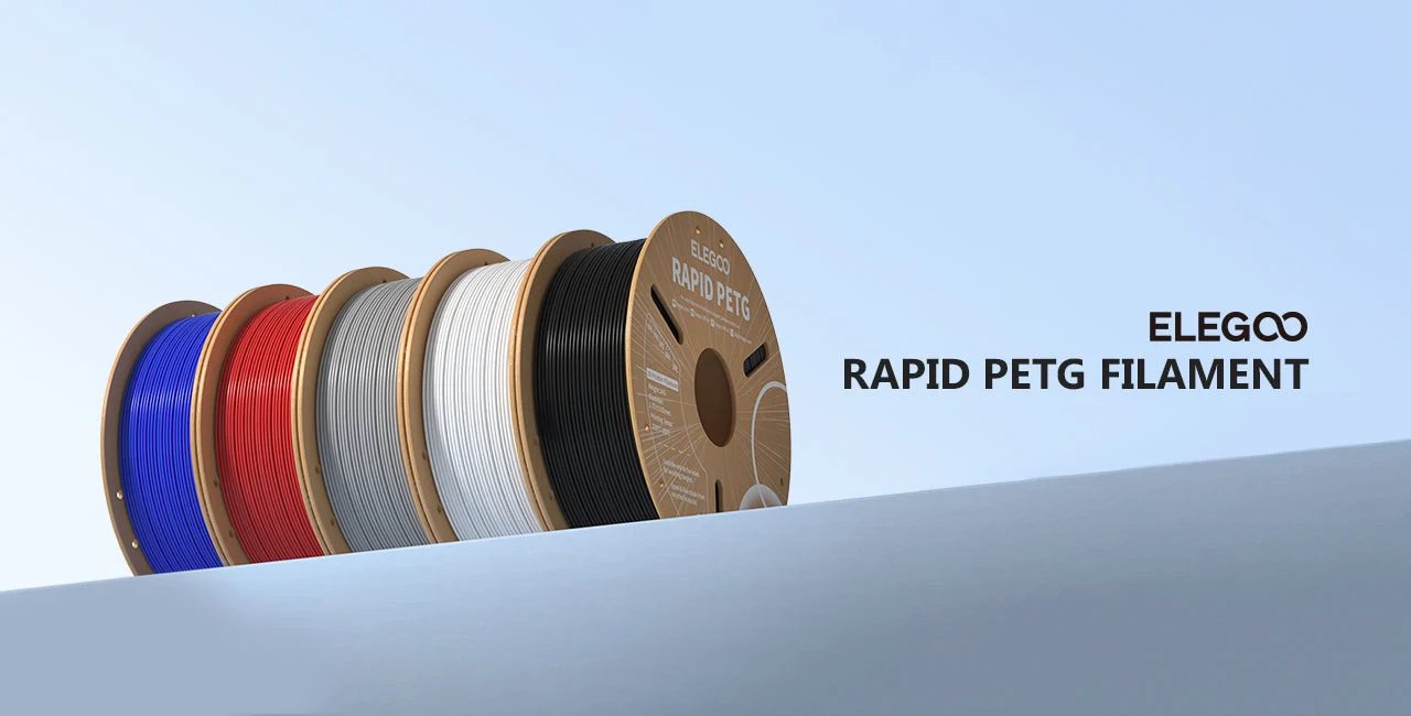 Cinco bobinas de filamento ELEGOO Rapid PETG — azules, rojas, grises, blancas y negras — colocadas en fila