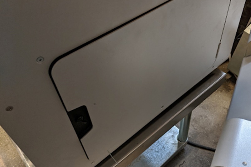 Puerta del armario de filtros cerrada en el lateral derecho de la impresora SLS Fuse 1, con el panel enrasado, esquinas redondeadas y tirador negro