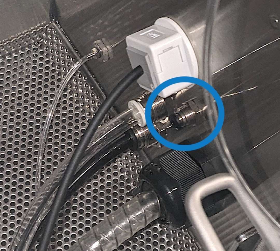 Primer plano del pasador plateado en el puerto de la cámara de granallado del Fuse Blast — retirar antes de instalar el tubo de inyección