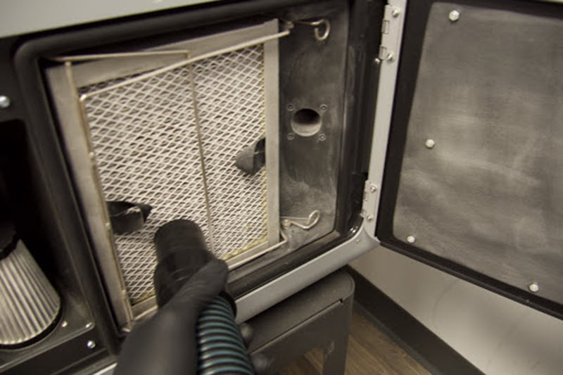 Manguera del aspirador del Fuse Sift aplicada sobre la rejilla del filtro de escape del Fuse 1 para eliminar el polvo acumulado antes de extraer el filtro