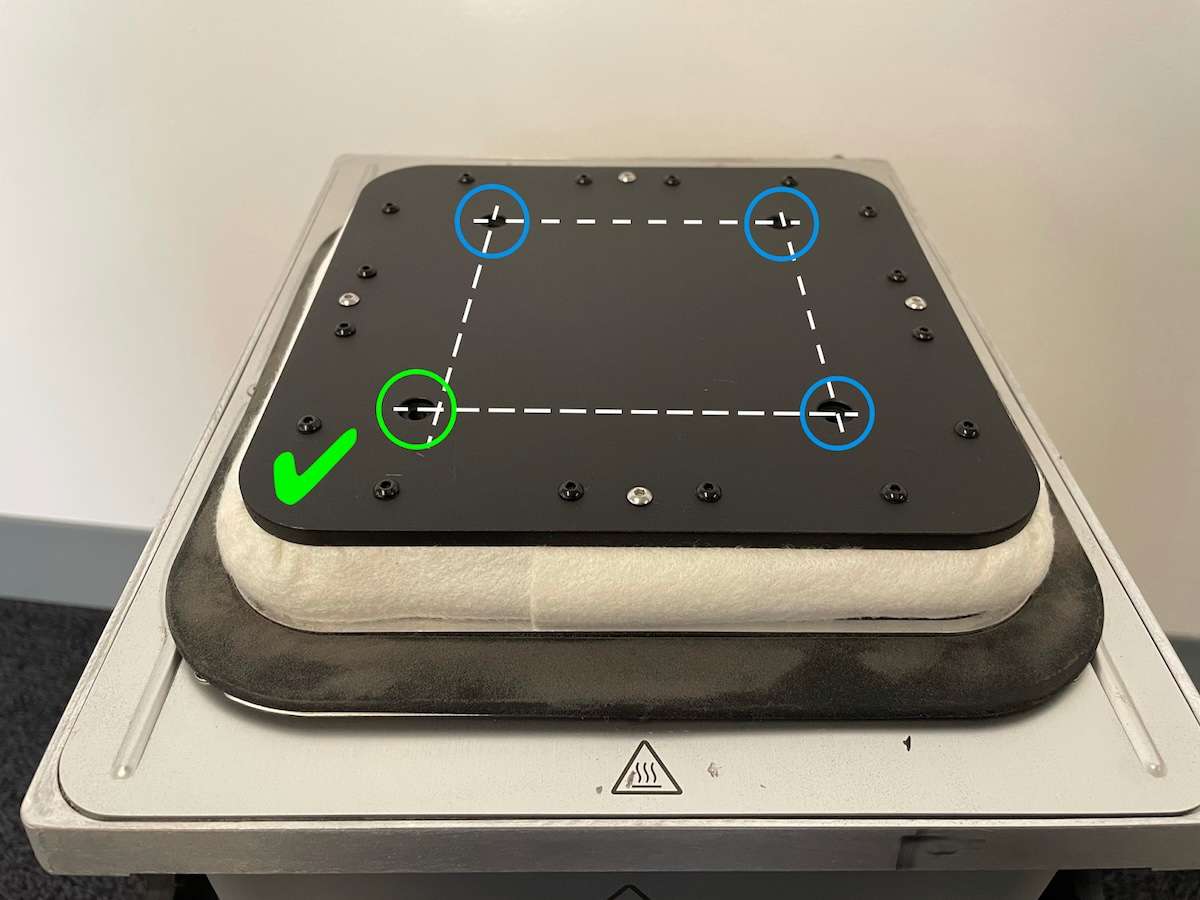 Plataforma de impresión de la cámara Fuse 1 instalada en orientación correcta — marca de verificación verde visible en el extremo delantero izquierdo donde el orificio desplazado se alinea correctamente