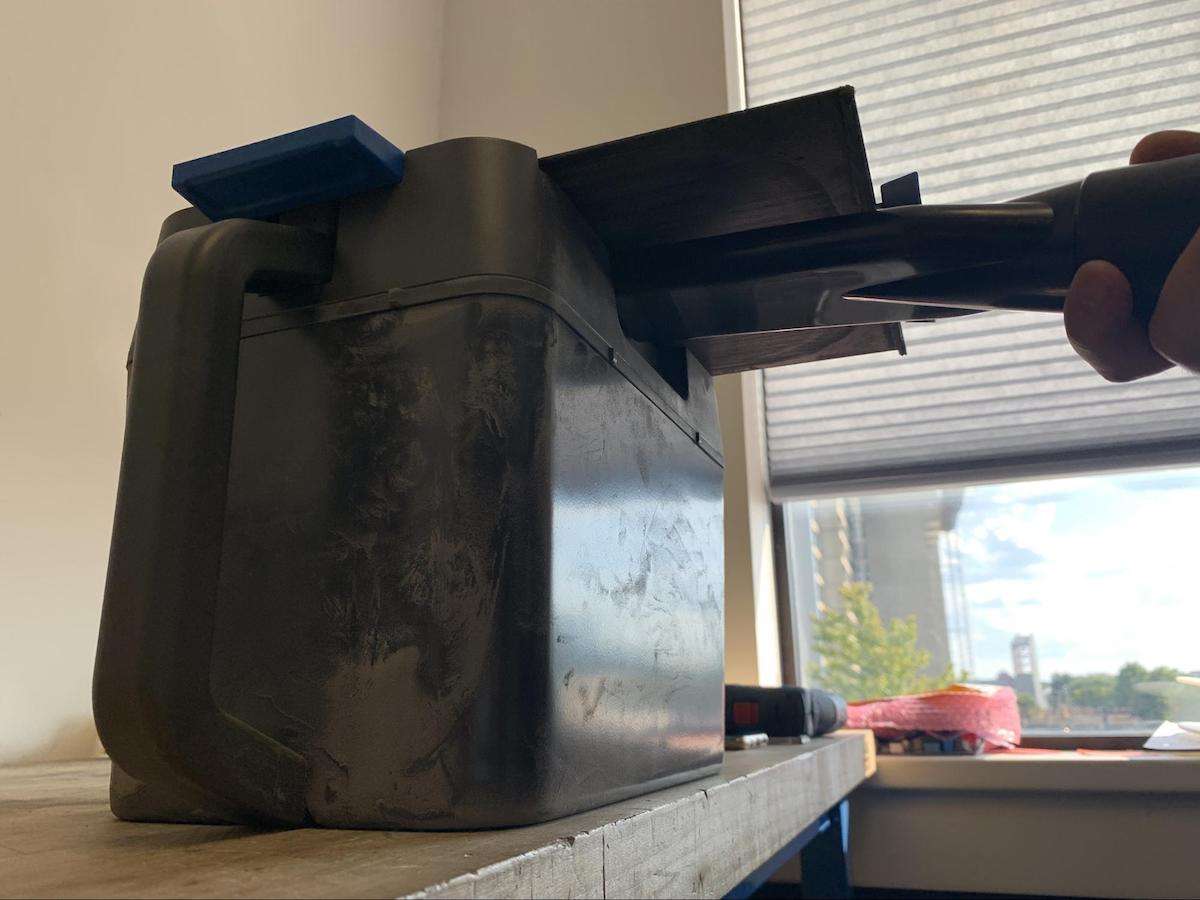 Boquilla de ranura del aspirador insertada bajo la válvula de cuchilla del Cartucho de Polvo Fuse Series, ligeramente a la izquierda del centro — Zona de limpieza 1, mantener 1 minuto con vacío activo