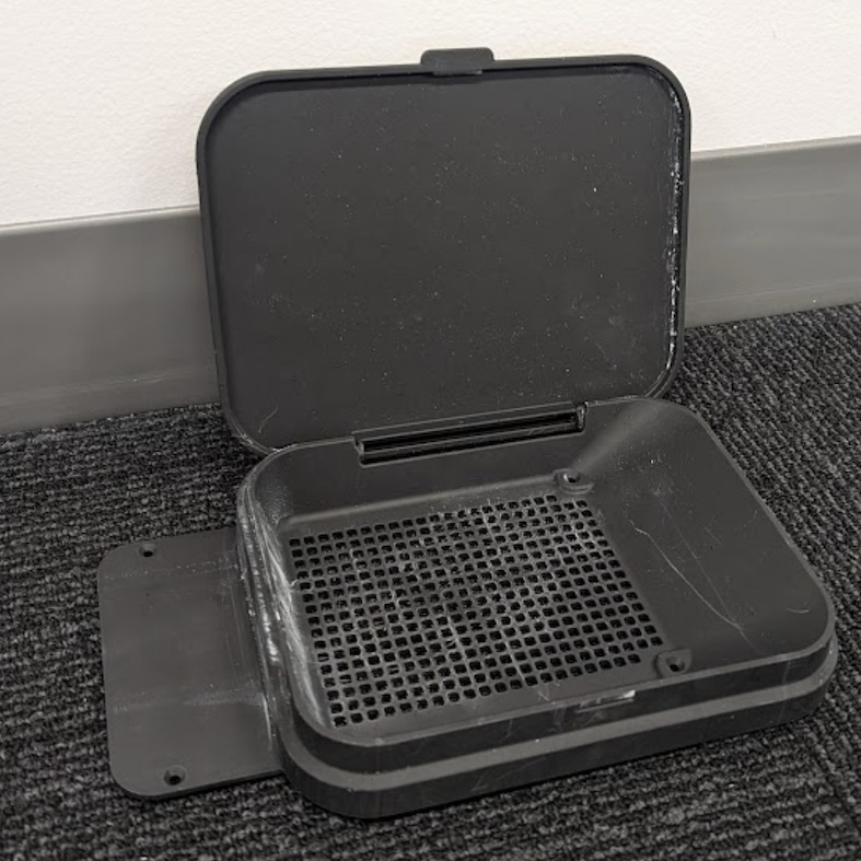 Accesorio Fuse Sift Funnel fotografiado de forma independiente con la tapa abatible completamente abierta, mostrando el filtro de malla y la carcasa de plástico negro