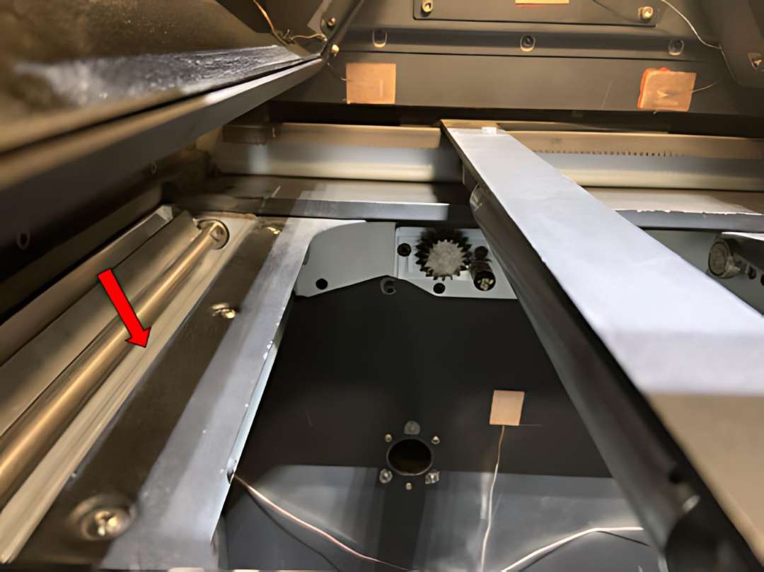 Flecha roja señalando el borde interior de la bandeja de polvo izquierda del Fuse 1 — zona crítica donde el polvo Nylon 11 se compacta con mayor frecuencia