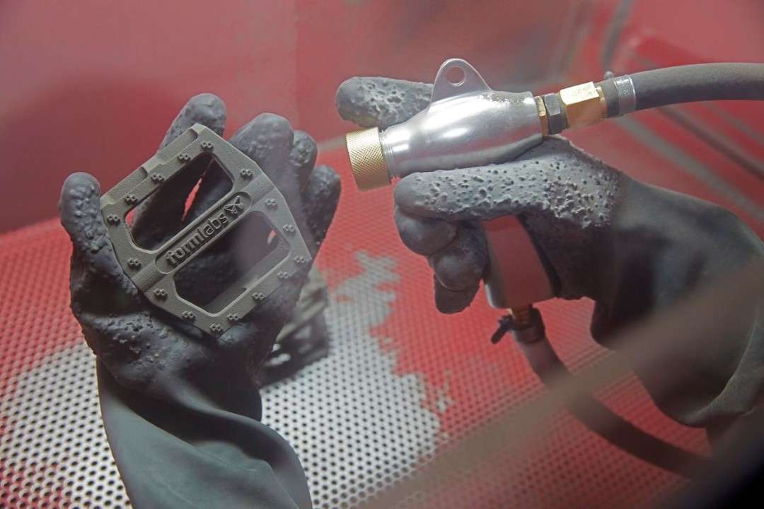 Granallado de un pedal de bicicleta impreso en Formlabs Nylon 12 GF para eliminar la Armadura Superficial dentro de una cabina de granallado