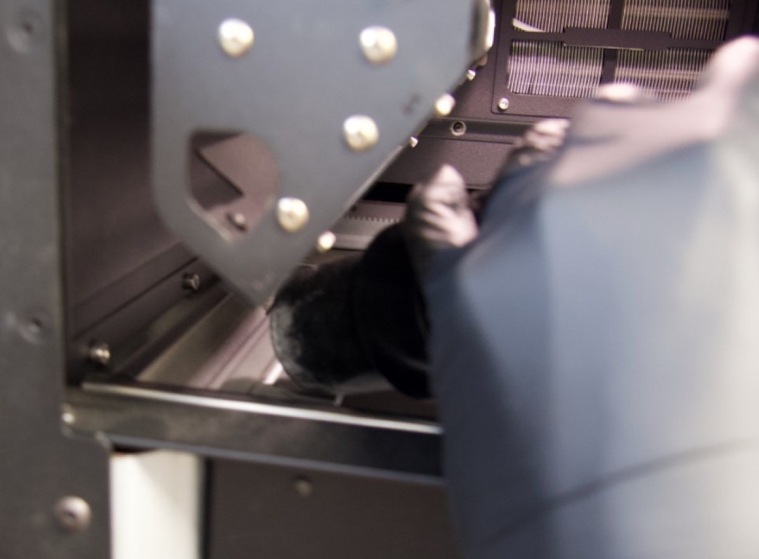 Aspirando la bandeja de polvo izquierda de la impresora Fuse 1 para eliminar el polvo Nylon 12 GF acumulado