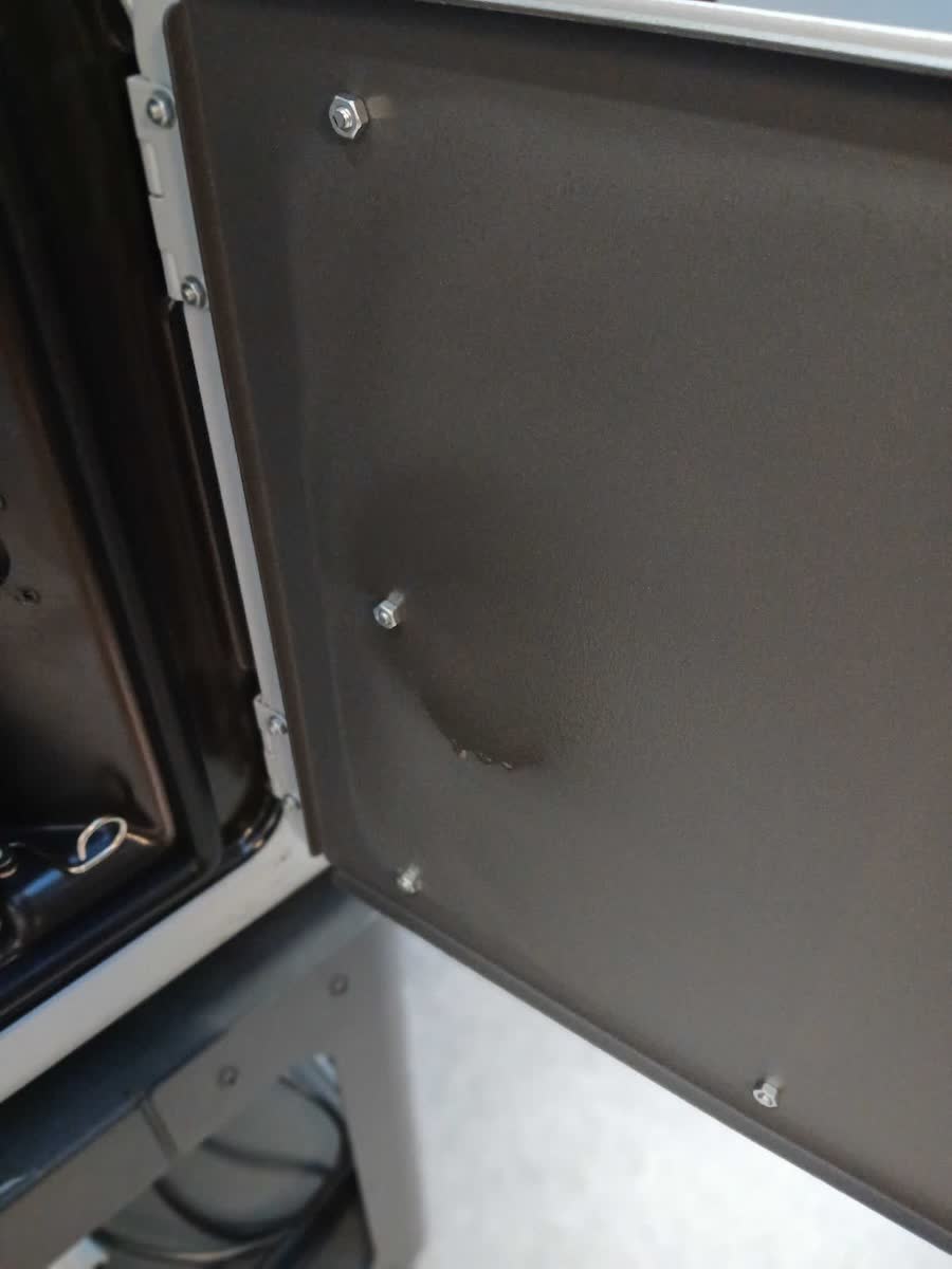 Interior de la puerta del armario de extracción de la Fuse 1 mostrando residuo oleoso de laurolactam del Nylon 12 Tough — limpiar con etanol