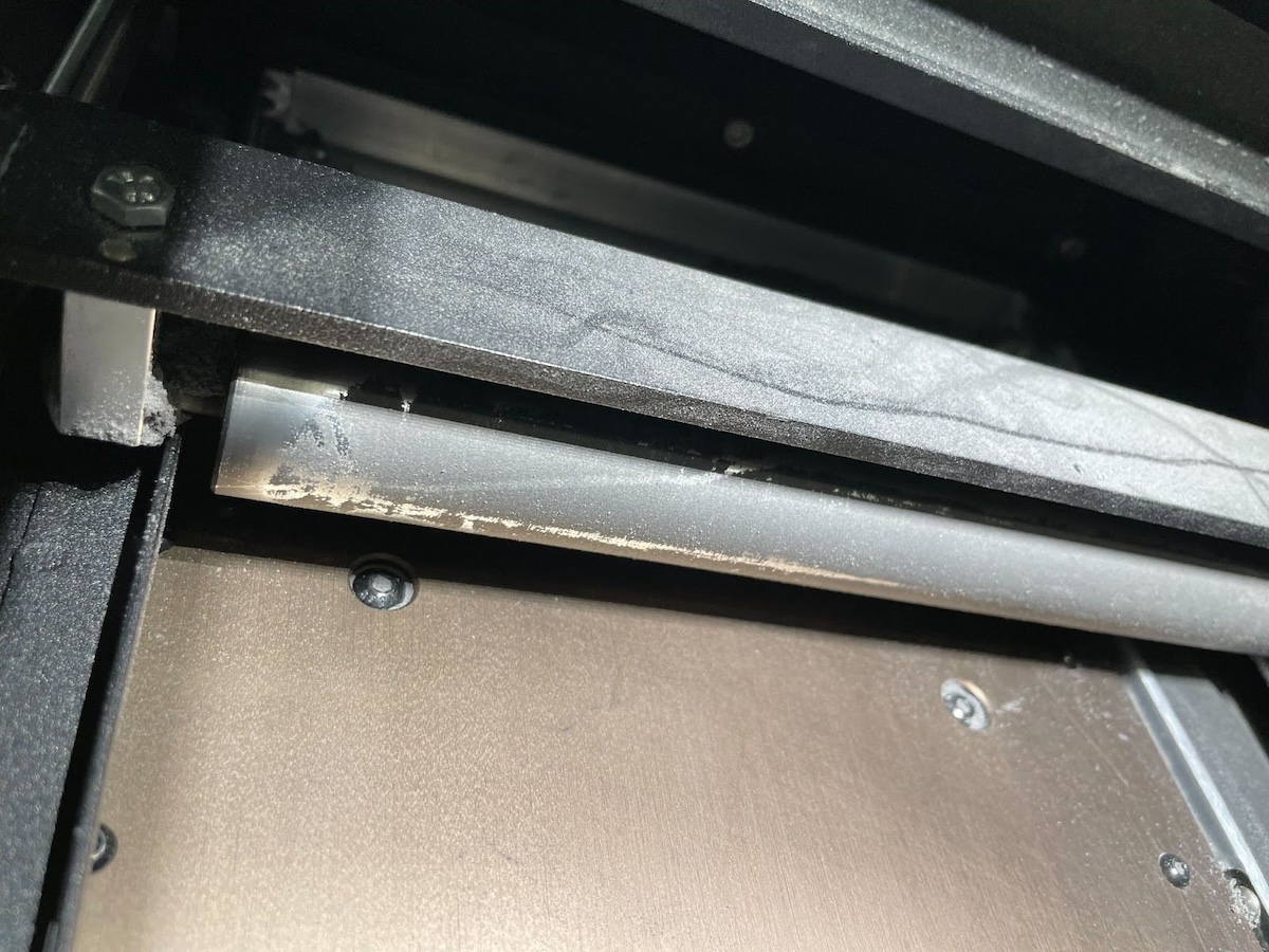 Cuchilla del recoater de la Fuse 1+ 30W mostrando acumulación de polvo semi-sinterizado blanco de Nylon 12 Tough que requiere limpieza con etanol