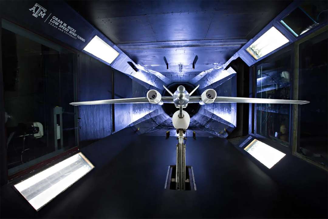 Modelo de avión con dos hélices, fijado en un soporte dentro de un túnel de viento