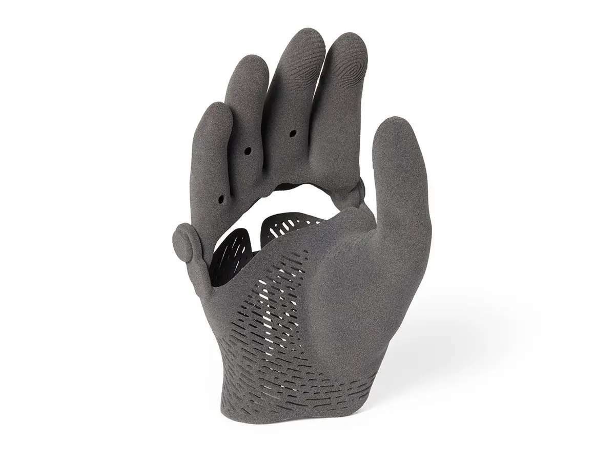 Variedad de piezas funcionales SLS en TPU 90A: suela de calzado, manguera corrugada, mano protésica, ortesis y pulsera en exposición