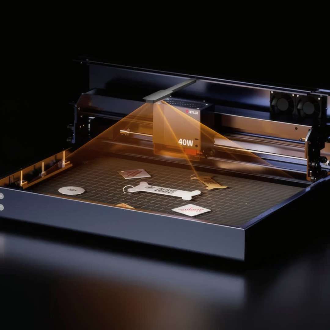 20 W laser head emitting a visible orange beam onto tag samples and a keychain on the worktable