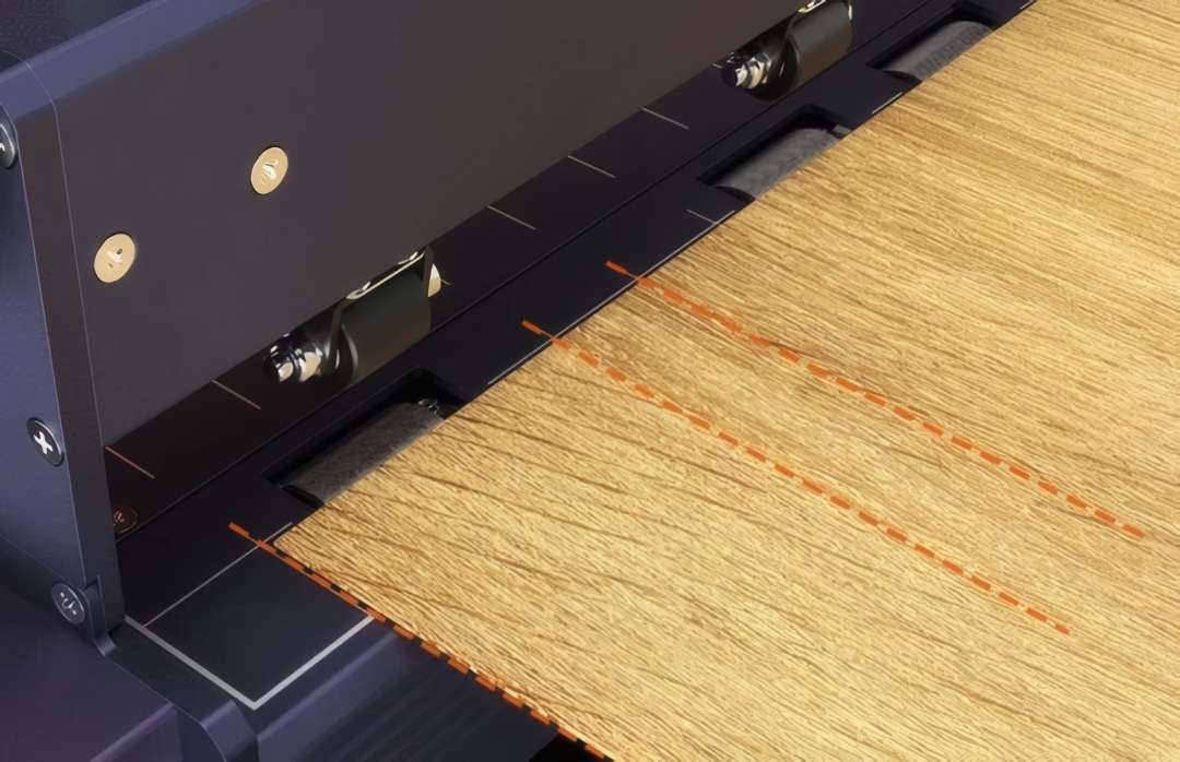 Feed rollers guiding a wooden sheet aligned to the laser positioning lines on the Ortur F10