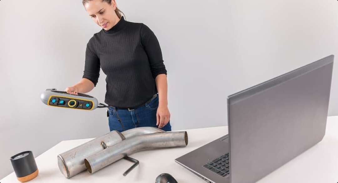Operador escaneando un tubo de escape de metal con el escáner portátil Peel 3