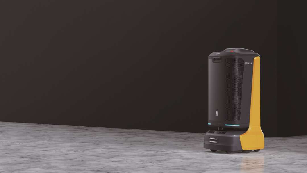 Robot de entrega PUDU FlashBot sobre suelo de mármol con fondo oscuro, mostrando el pilar lateral amarillo, el panel de tejido de carbono, la apertura del sensor LiDAR y la cámara RGBD superior