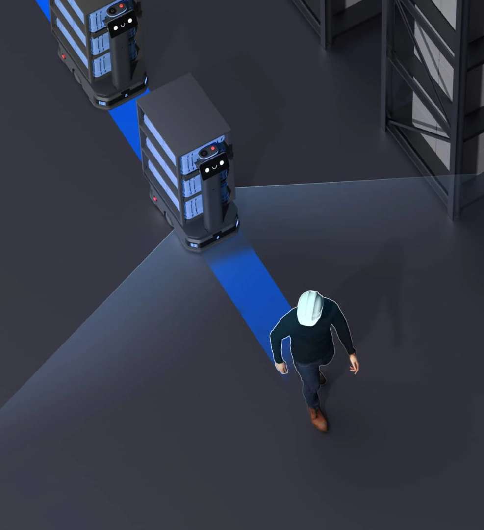 Robots PUDU T300 en modo seguimiento rastreando a un operario con casco en una instalación industrial oscura