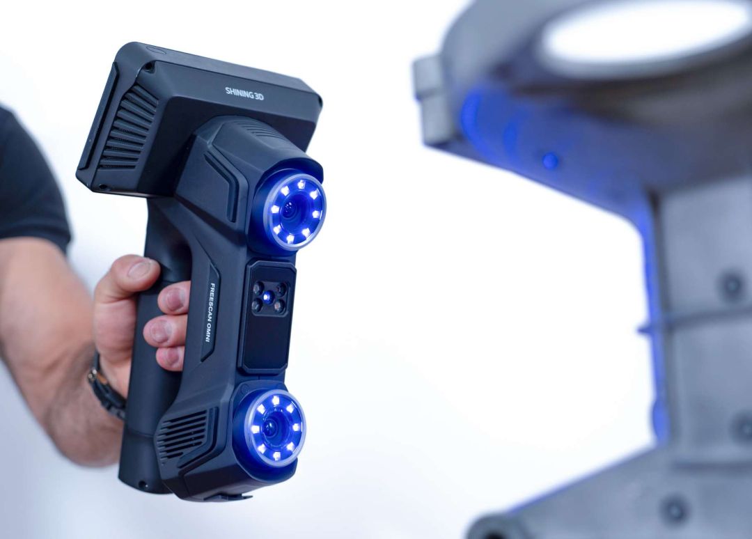 Primer plano del escáner 3D portátil FreeScan Omni con doble anillo de cámaras iluminado y módulo de batería extraíble