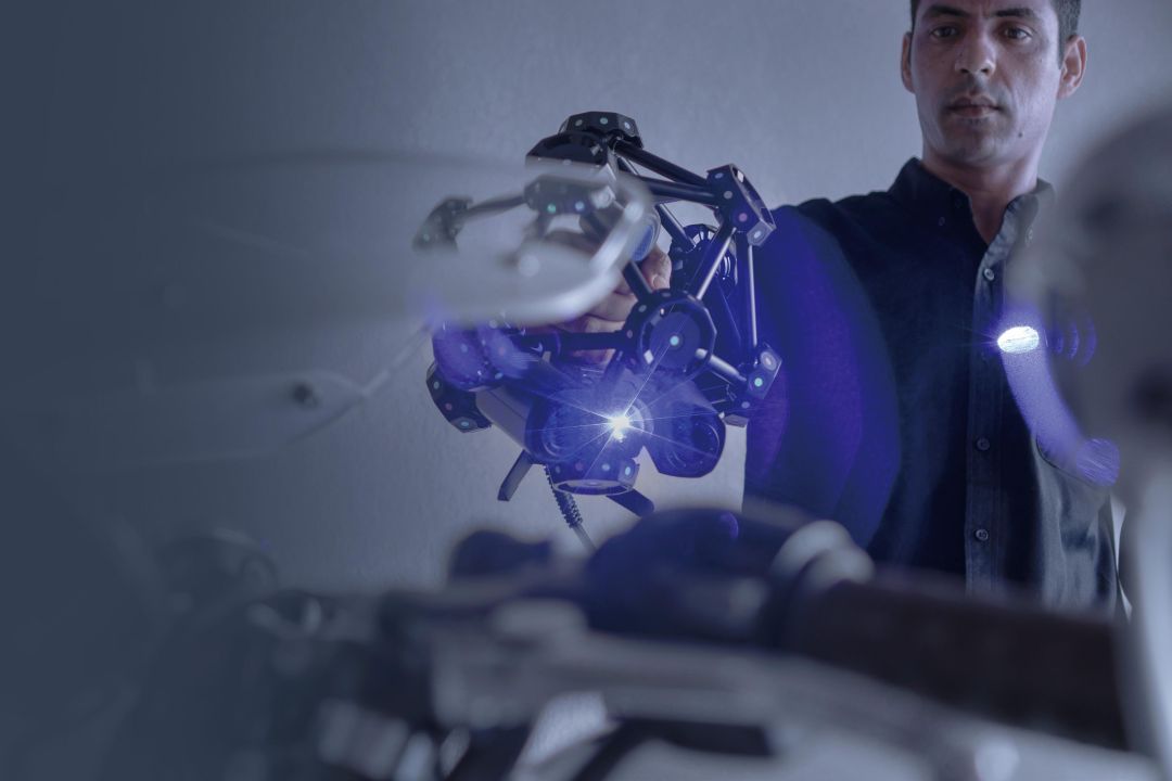 Primer plano del escáner TE25 proyectando líneas láser azules sobre un panel de puerta de automóvil con un mapa de desviación de color mostrando la precisión de 0,023 mm