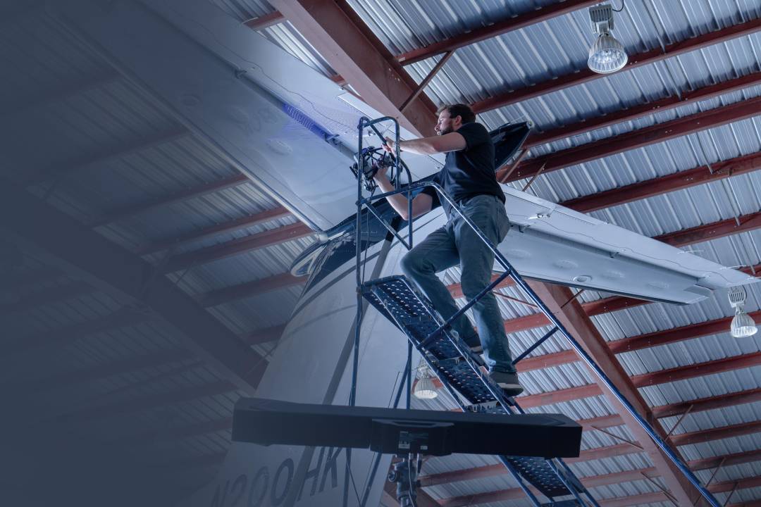 Técnico escaneando la parte inferior del fuselaje de una aeronave con el FreeScan Trak Pro2, demostrando la capacidad de escaneo de amplio rango