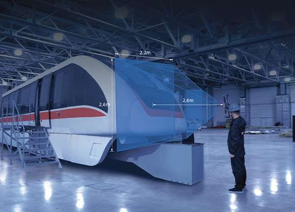 Operador escaneando un vagón ferroviario con FreeScan UE Nova, mostrando la superposición del campo de visión de 2,6 × 2,2 m en una nave industrial