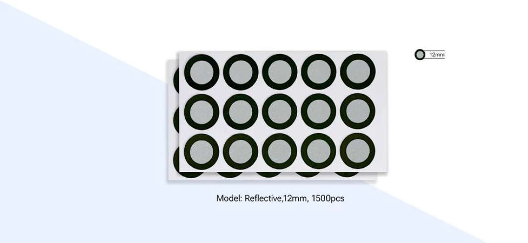 Dos hojas de marcadores reflectantes circulares de 12 mm de Shining3D EinScan dispuestas en una cuadrícula de cinco por tres, mostrando el set completo de 1500 piezas