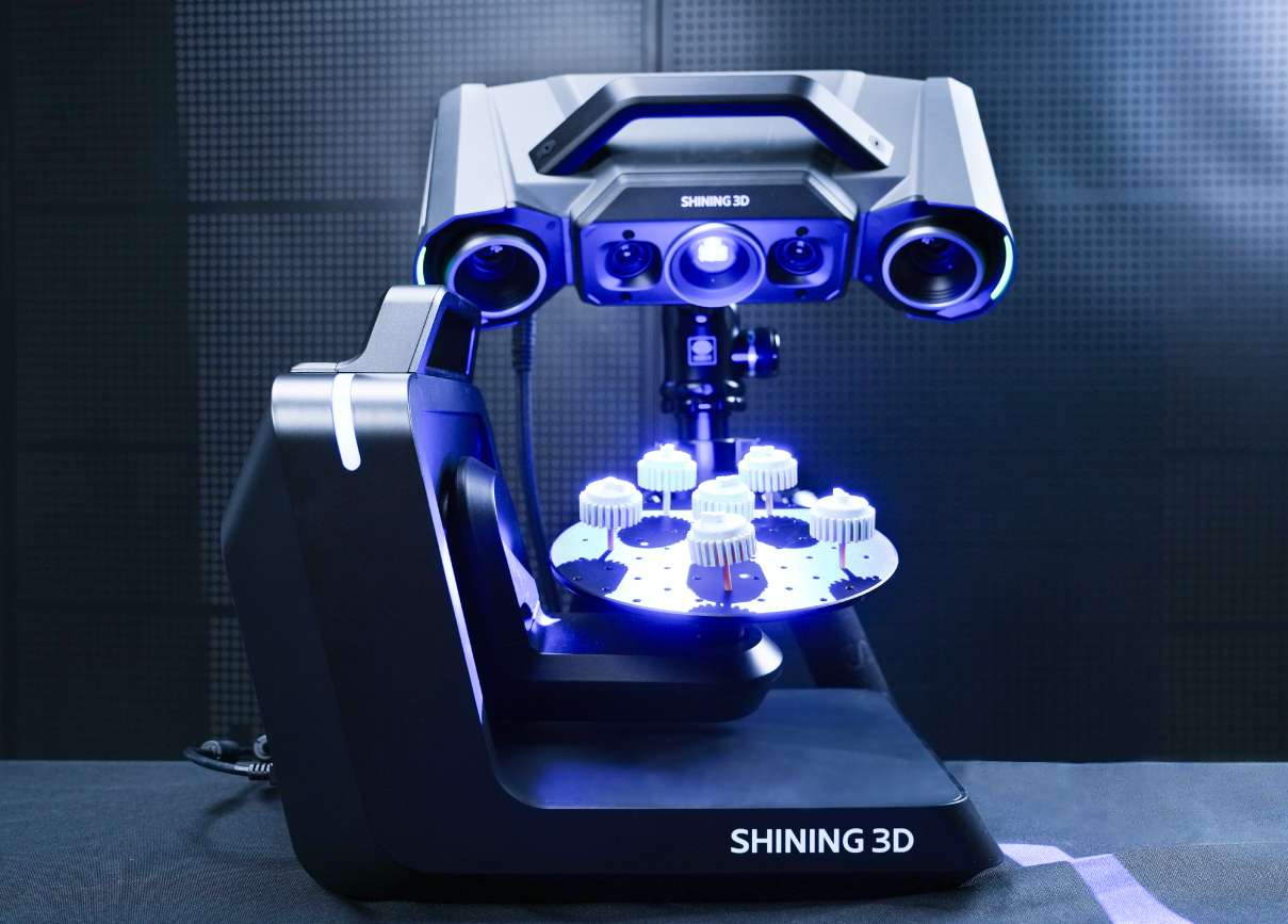 OptimScan Q9 emparejado con la plataforma rotatoria automática de doble eje Shining 3D escaneando pequeños engranajes blancos en un laboratorio