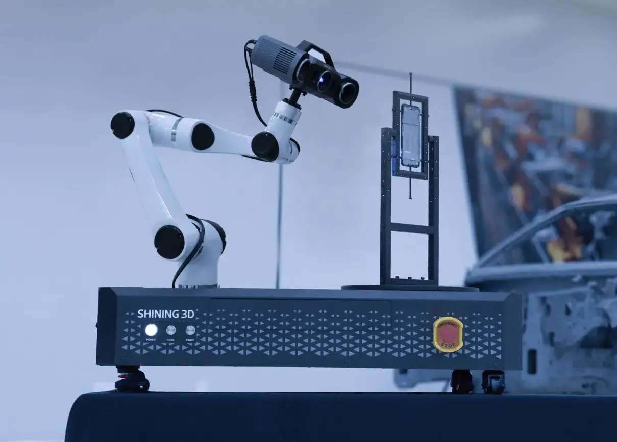 OptimScan Q9 montado en un brazo robótico sobre un banco de inspección automatizada Shining3D con carrocería en blanco al fondo
