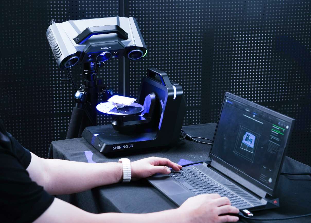 Plataforma rotatoria portátil todo en uno de doble eje Shining3D sobre banco con una pieza pequeña tipo escuadra siendo escaneada por el OptimScan Q9