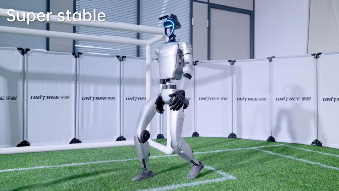 Robot humanoide Unitree G1-Comp demostrando equilibrio superestable y control de marcha sobre césped artificial en pista interior