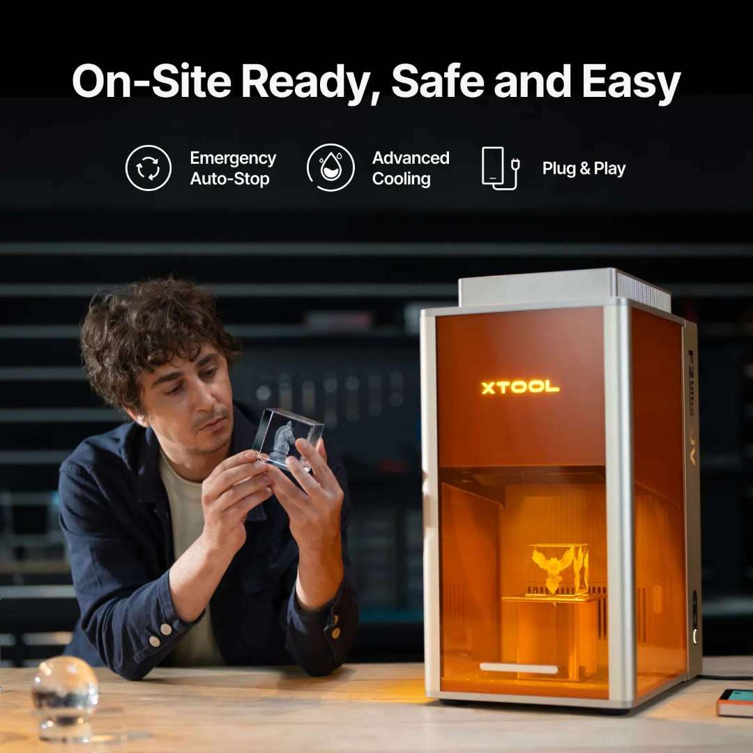 Operador profesional examinando un bloque de cristal con grabado interior 3D terminado junto a la máquina xTool F2 Ultra UV, con iconos que destacan la parada de emergencia automática, la refrigeración avanzada y las características Plug-and-Play
