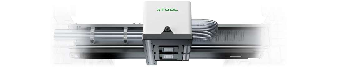 Carro blanco de xTool con un pequeño objetivo de cámara y un cable plano sobre una guía metálica horizontal