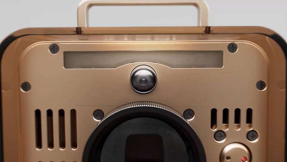 Primer plano de un dispositivo electrónico de color dorado metálico con múltiples lentes de cámara y un asa superior.